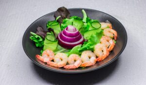 A vibrant salad featuring shrimp, cucumber, and onion, perfect for healthy eating.